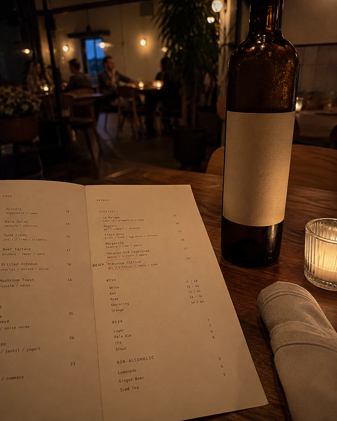 Restaurant menu on a candlelit table with a new SKU added by hand